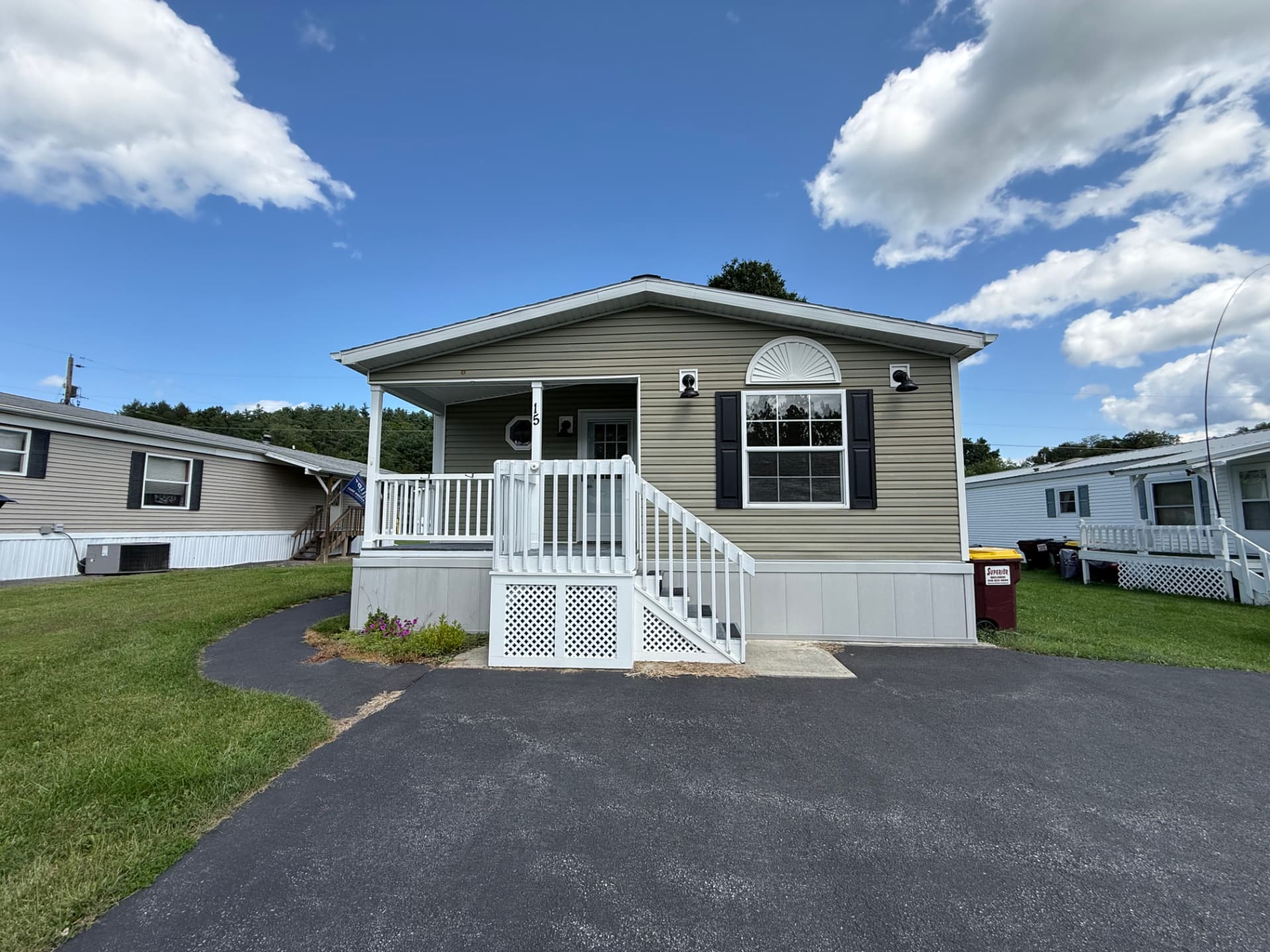 Front exterior of 15 Kevin, a manufactured home with a covered porch and paved drive