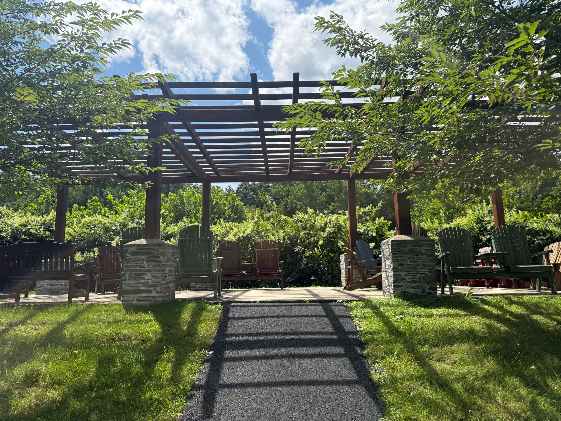 The pergola and walking path across the open lawn at Tuscany Meadows